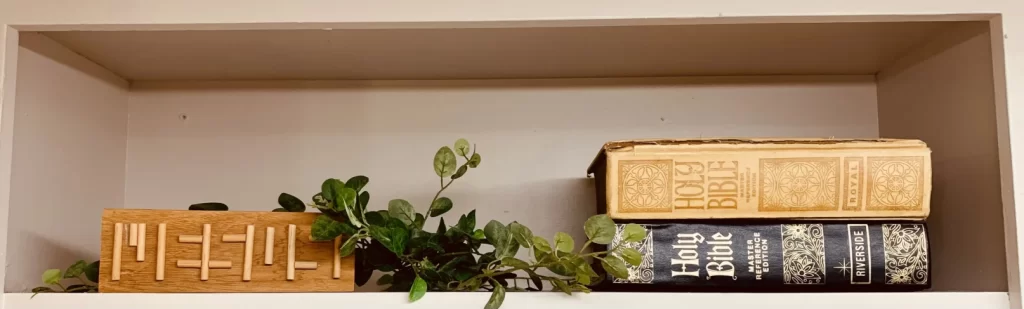 Shelf with books and Jesus sign